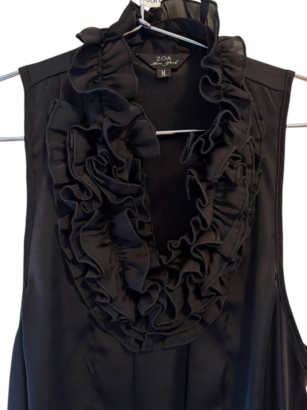 ZOA New York featuring a dramatic, cascading ruffle black silky top